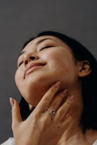 woman touching her neck decoratively